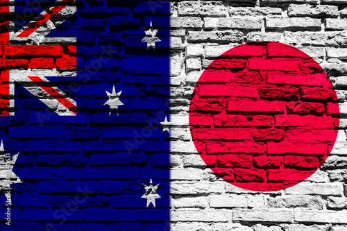 Background with flag of Japan and Australia on a brick wall
