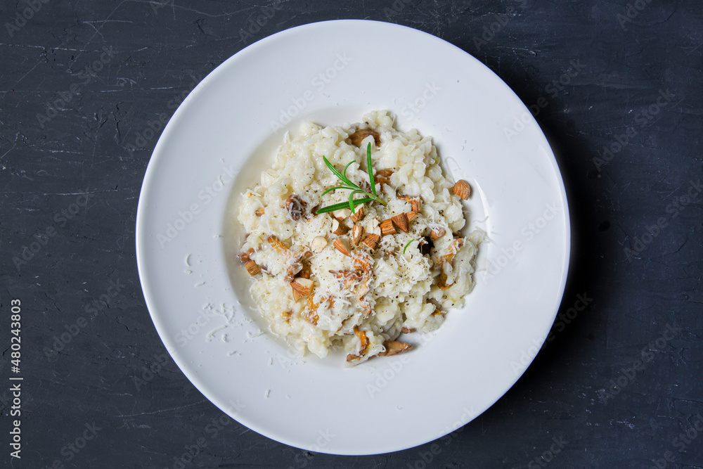 Tasty creamy risotto with mushrooms and almonds, top view. Traditional italian cuisine. 
