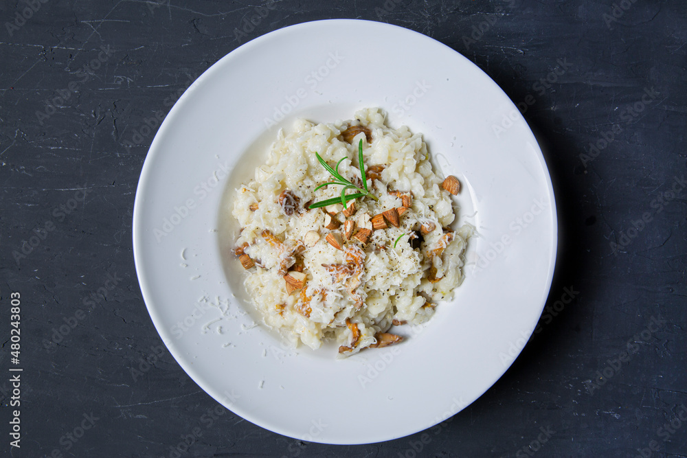 Tasty creamy risotto with mushrooms and almonds, top view. Traditional italian cuisine. Tasty creamy risotto with mushrooms and almonds, top view. Traditional italian cuisine.
