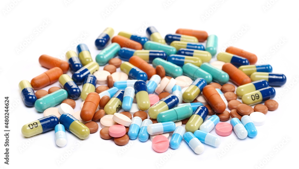 Different types of pills, colorful medical tablets pile isolated on white  