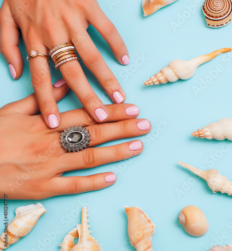 beautiful woman hands with pink manicure holding plate with pearls and sea shells  luxury jewelry concept