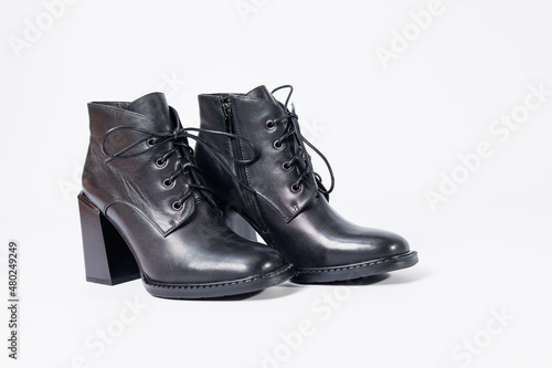 Women's boots with black genuine leather on heels isolated on a white background. photo from the side, diagonally and foreshortened from behind. Women's shoe collection 2022