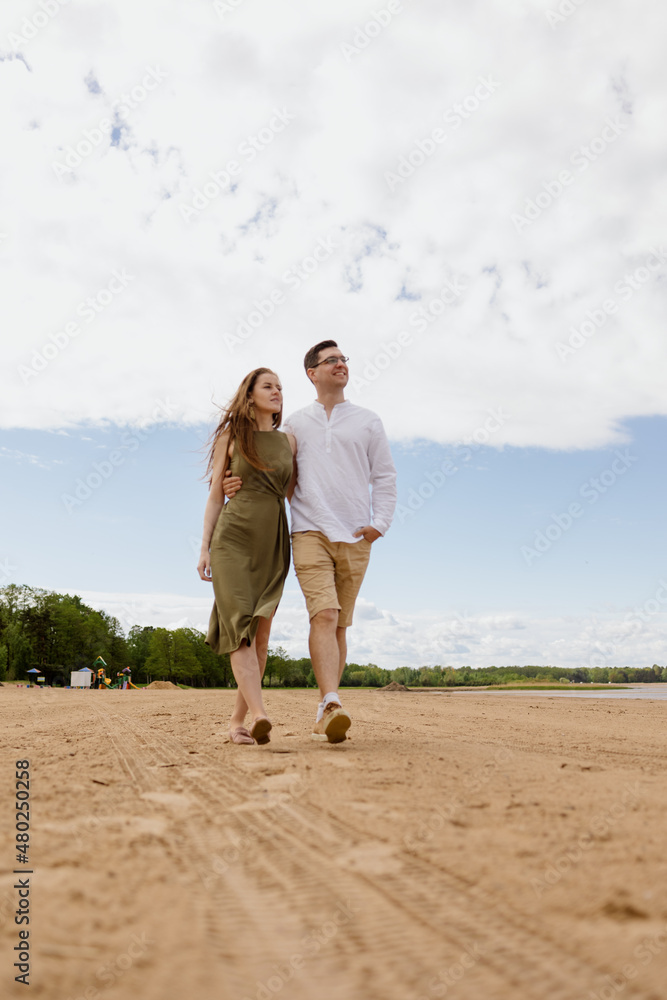 a couple of a man and a woman are walking on the beach or running along the sand along the seashore. beautiful and young European man and woman on a romantic walk in nature, a couple in love, a happy a couple of a man and a woman are walking on the beach or running along the sand along the seashore. beautiful and young European man and woman on a romantic walk in nature, a couple in love, a happy