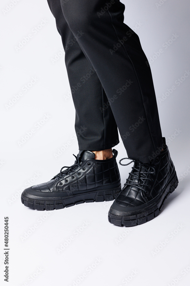 Men's black boots made of genuine leather, men's footwear on a white background. Winter men's shoes 2022