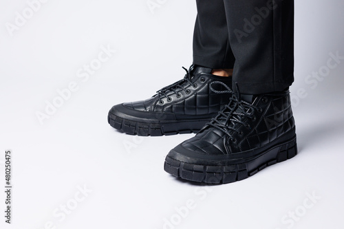 Men's black boots made of genuine leather, men's footwear on a white background. Winter men's shoes 2022