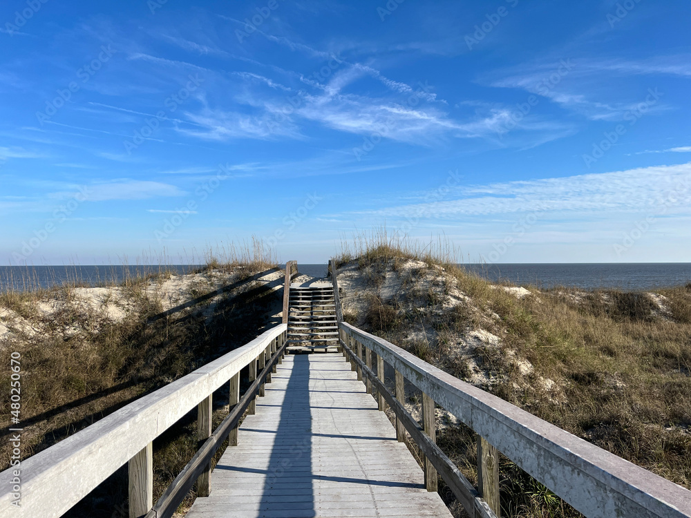 A boardwalk over the sand dunes to the Atlantic ocean on Jekyll Island, Georgia, a popular slow travel destination.