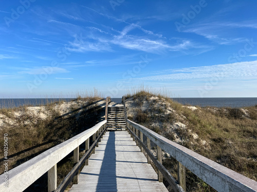 A boardwalk over the sand dunes to the Atlantic ocean on Jekyll Island  Georgia  a popular slow travel destination.