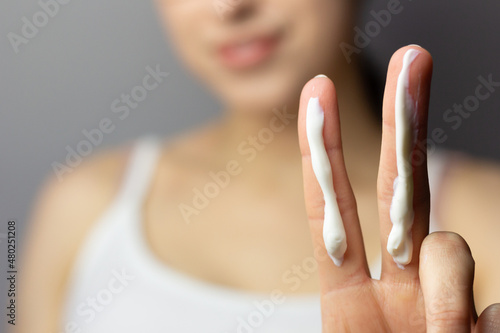 Young woman applying the correct amount of sunscreen for face and neck. photo