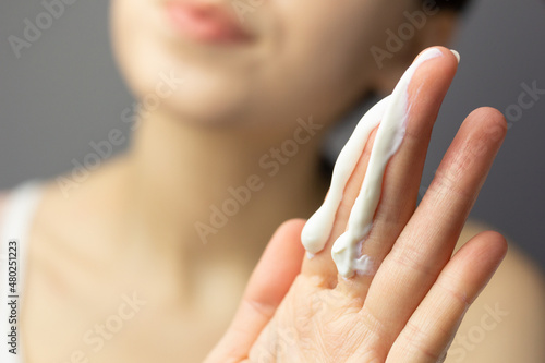 Foto Young woman applying the correct amount of sunscreen for face and neck