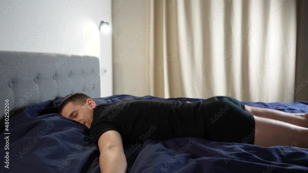 Slow motion. The guy falls into bed with a running start. Landing in bed. Pleasure on the face Slow motion. The guy falls into bed with a running start. Landing in bed. Pleasure on the face