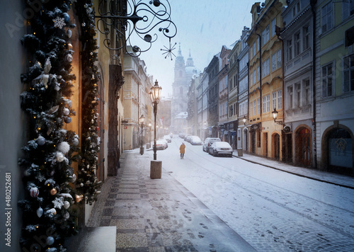 A road to St. Nicolas church in Prague in winter during christmas with snow. Christmas decorations. Person. Prague. Europe. Christmas. © Denis Poltoradnev