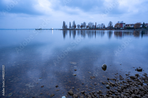 Der beruhigende Sonnenuntergang im Hafen von Immenstaad am Bodensee zeigt die wunderschönen Farben der bunten Wolken im Wasser photo