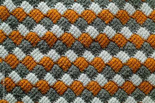 Tunisian crochet fabric. Crocheted white, yellow, grey entrelac. photo
