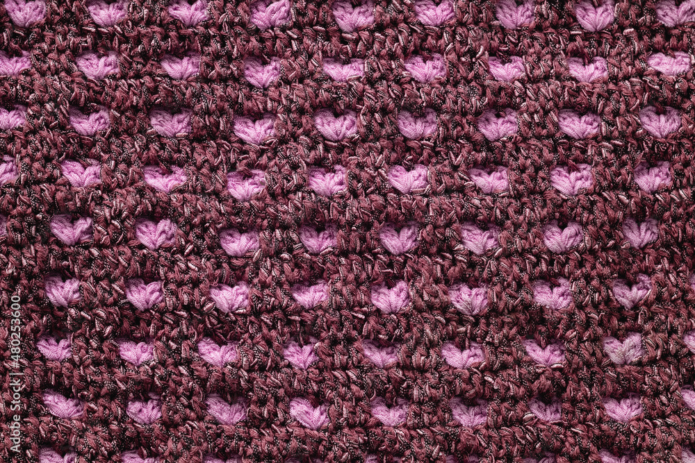 Violet and pink crocheted geometric pattern. Knitted texture.