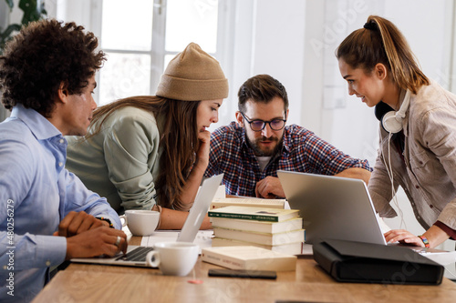 Group of casually dressed young businesspeople discussing ideas at the office about a new startup project.Female coworker talking about business strategy.	
