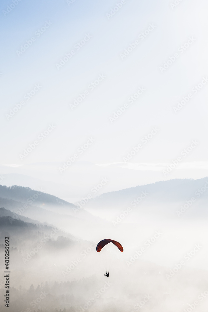 Red parachute in the sky above the mountains Red parachute in the sky above the mountains
