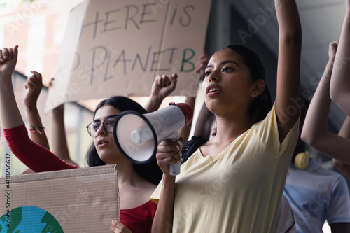 Female hispanic latin teenager students with placards and posters on global protest for climate change and Earth rights