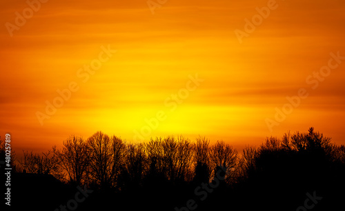 a powerful intense sunrise fills the horizon with a fiery blanket of red  orange and yellow  Wiltshire UK