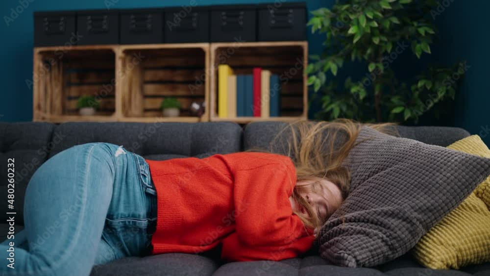 Young blonde woman lying on sofa sleeping at home Young blonde woman lying on sofa sleeping at home