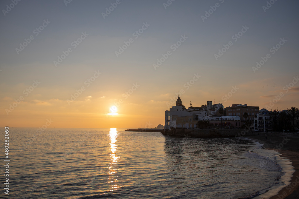 Barcelona, Spain - November 20, 2021: Rest at the sea. Evening landscape with architecture, cafe on the background of the azure sea. Evening in the city of Sitges, Spain, Catalonia.