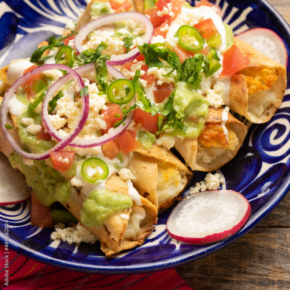 Mexican fried potato tacos called flautas with guacamole and cheese Stock Photo Adobe Stock