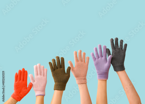 Women in warm gloves on blue background