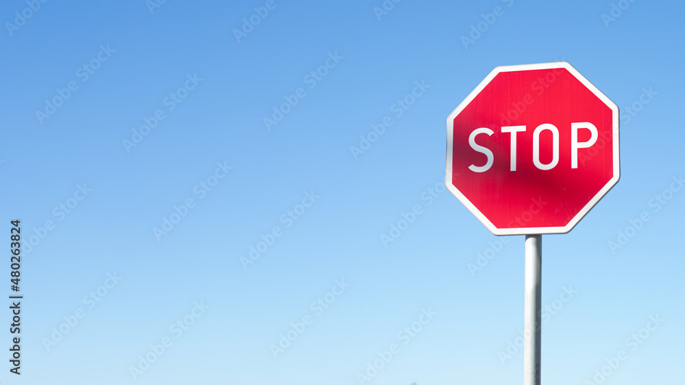 STOP - Czerwony znak stop na niebieskim tle, zatrzymać się , symbol, sprzeciw - obrazy, fototapety, plakaty 