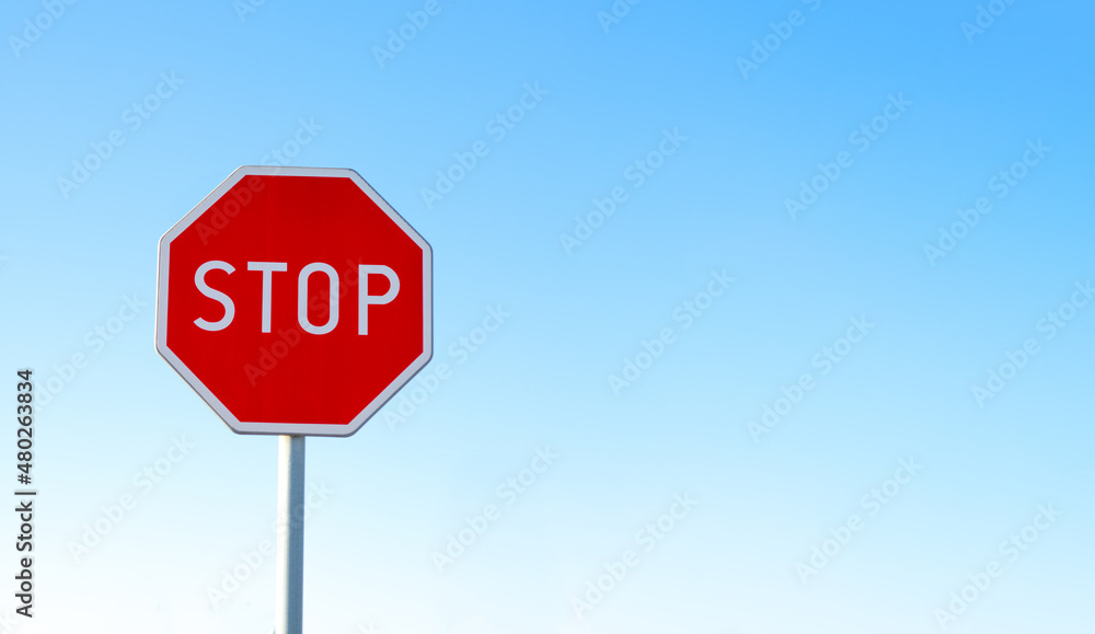 STOP - Czerwony znak stop na niebieskim tle, zatrzymać się , symbol, sprzeciw