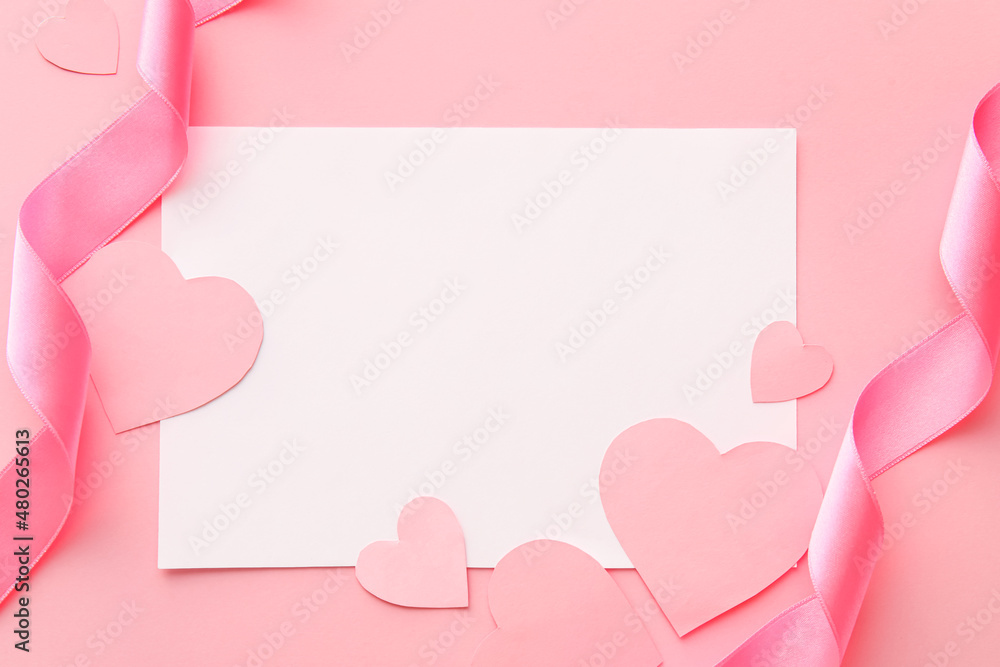 Composition with blank card, ribbons and paper hearts on pink background, closeup. Valentine's Day celebration