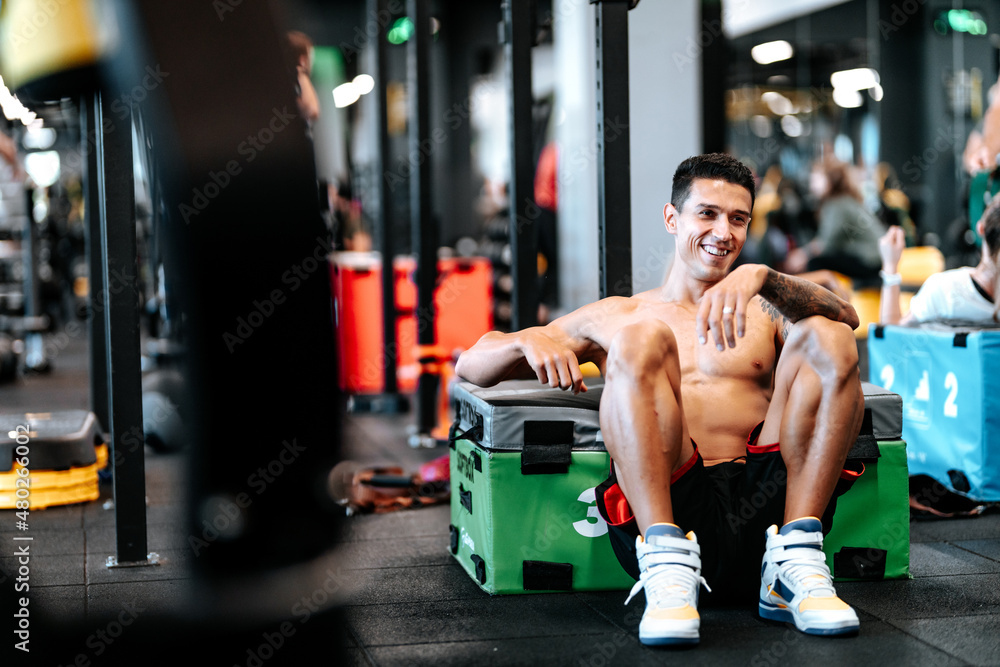 Portrait of smiling handsome man during workout at gym,