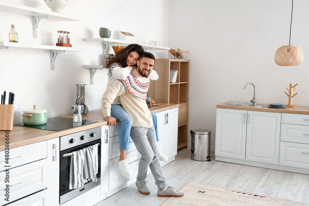 Happy young couple wearing warm sweaters at home Happy young couple wearing warm sweaters at home