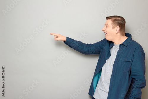 фотография Portrait of goofy cheerful mature man pointing at something funny