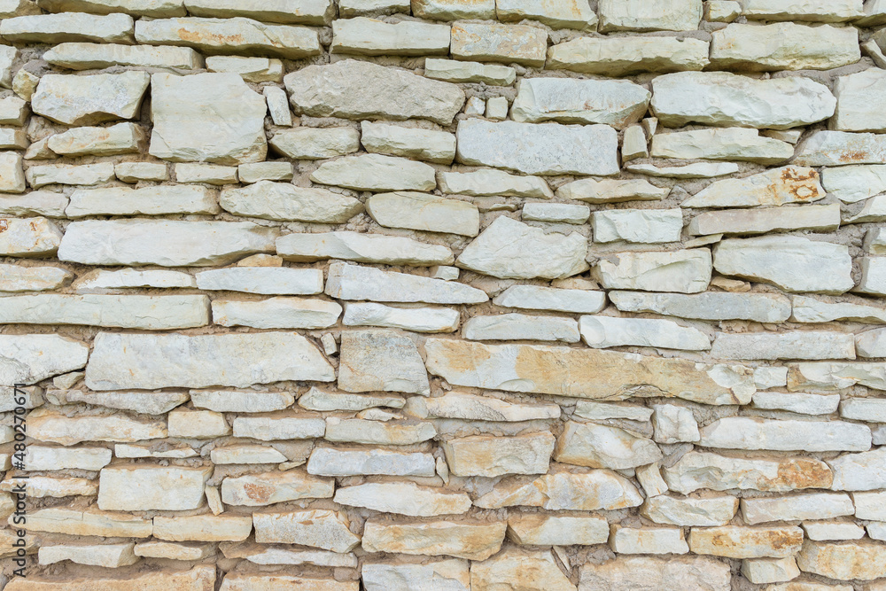 Fototapeta premium Stone wall texture with different sized stones as background