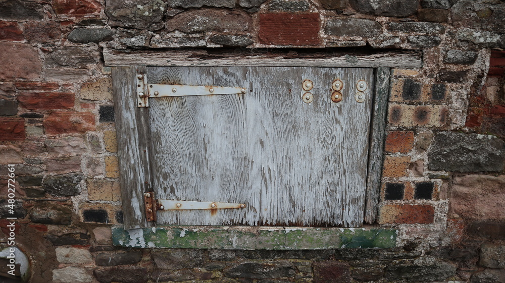 Naklejka premium Small light blue door on an old cottage