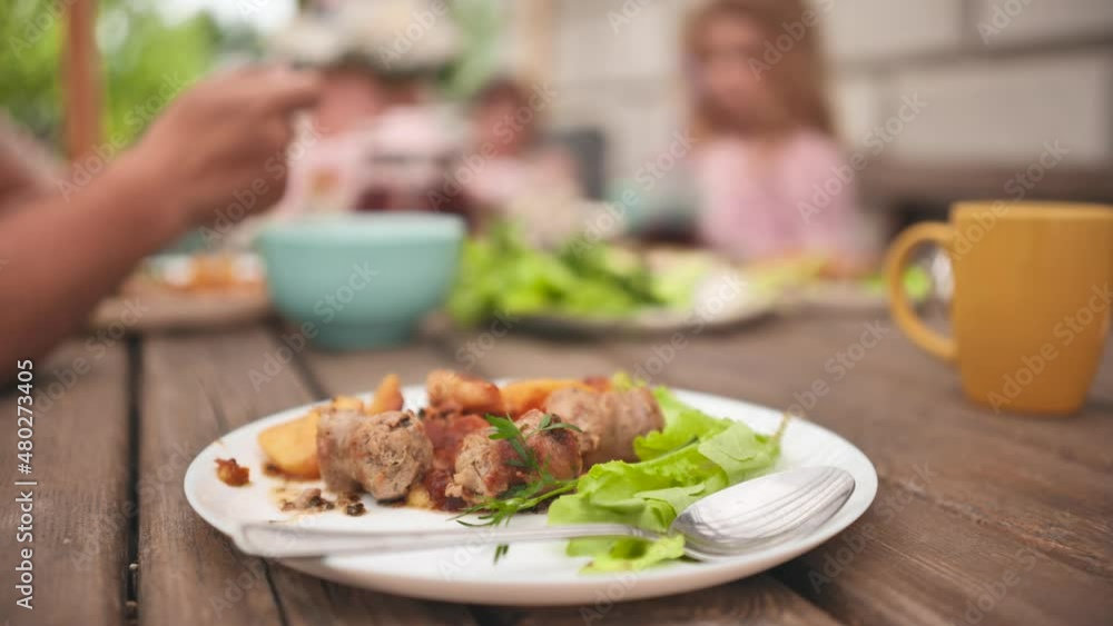 The family dines on a meal of roast potatoes and meat. The family dines on a meal of roast potatoes and meat.