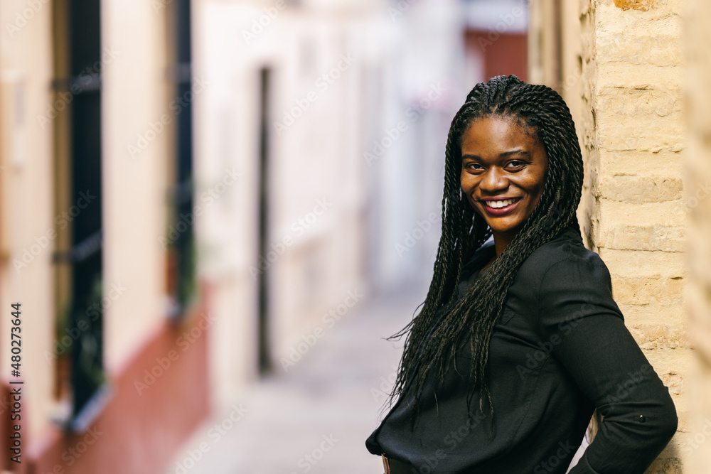 African woman leaning on a brick wall outdoors African woman leaning on a brick wall outdoors