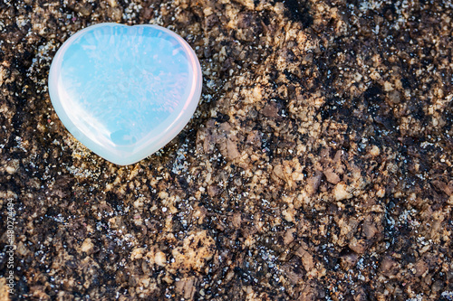 Gem stone heart on a rough surface, copy space.