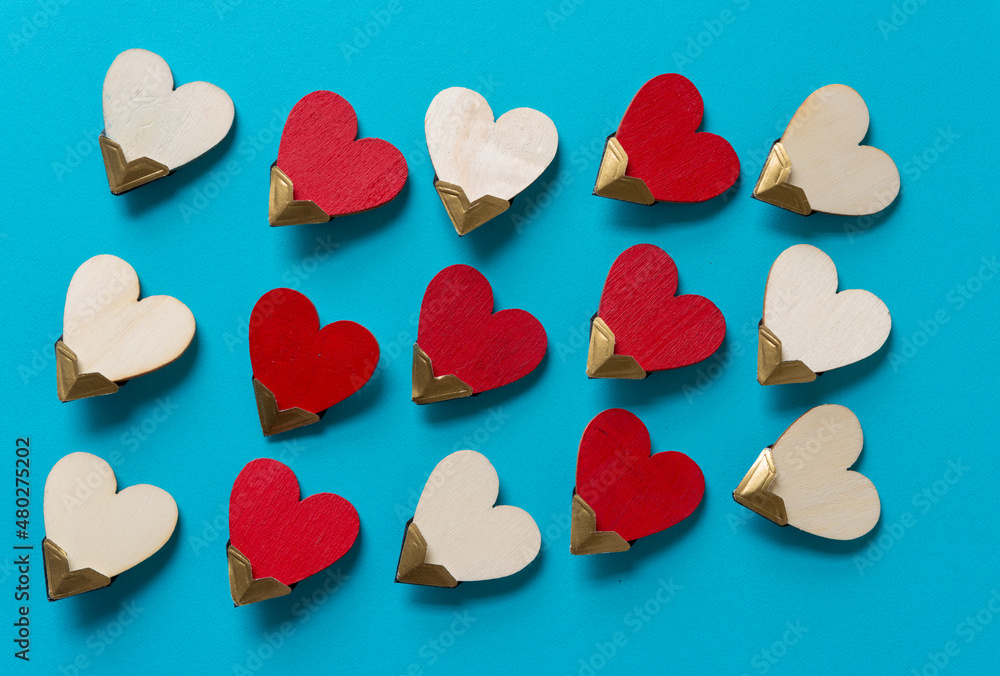 painted and plain wooden hearts on blue paper painted and plain wooden hearts on blue paper