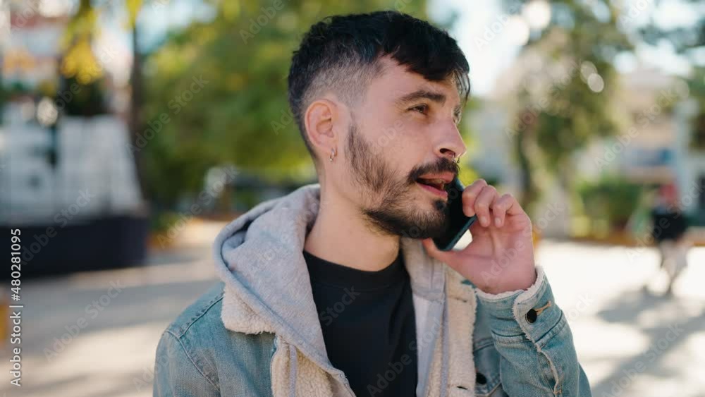 Young hispanic man with serious expression talking on the smartphone at park Young hispanic man with serious expression talking on the smartphone at park