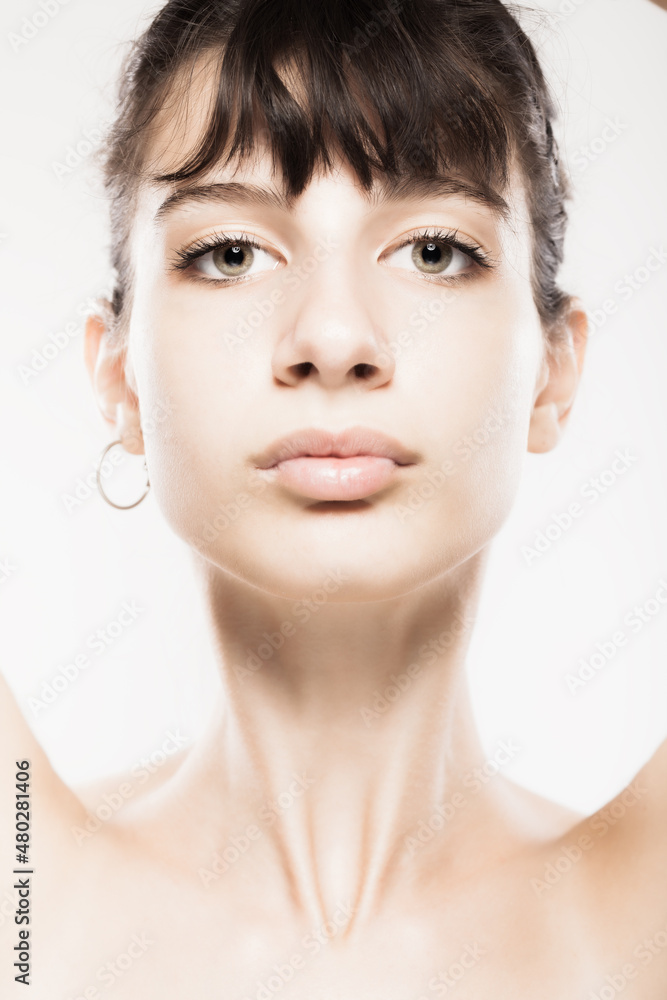 Fototapeta premium Beautiful young girl studio portrait. Looking at camera.