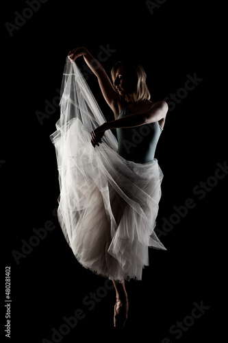 Fototapeta Naklejka Na Ścianę i Meble -  ballerina with a white dress and black top posing on black background