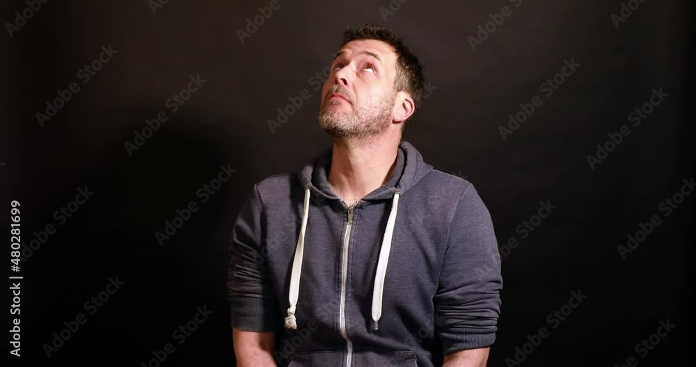 man looks up in amazement against a black background man looks up in amazement against a black background