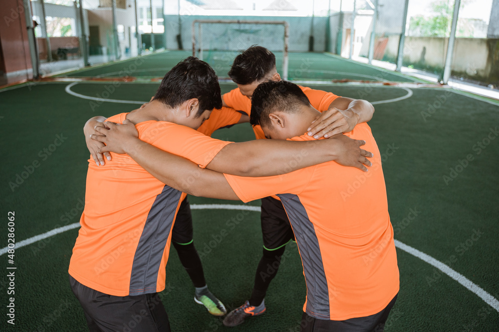 group of futsal players gather in a circle before game