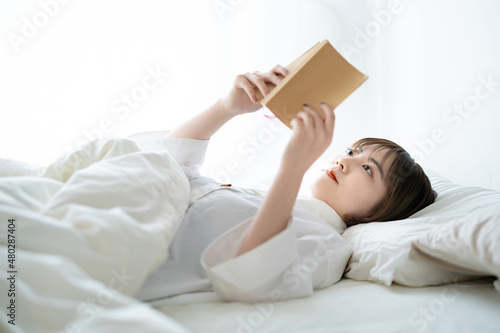 ベッドで本を読む女性