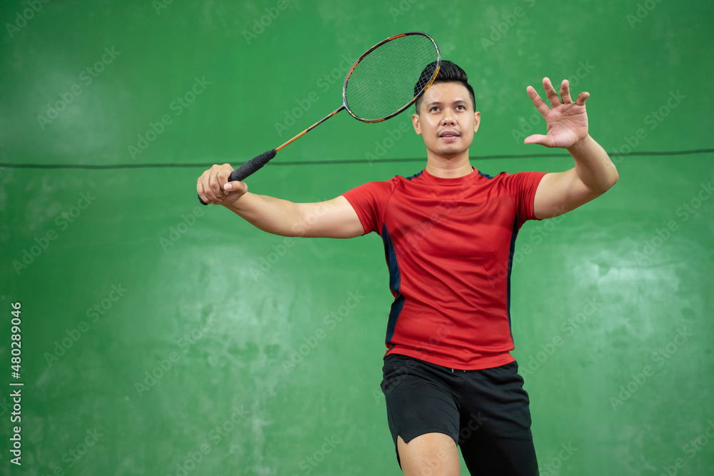 Male badminton player standing in a position ready to swing