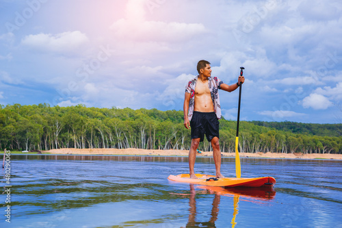 Photography Young man have fun on stand up paddle board