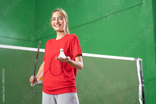 Smiling female badminton player holding racket and shuttlecock © Odua Images