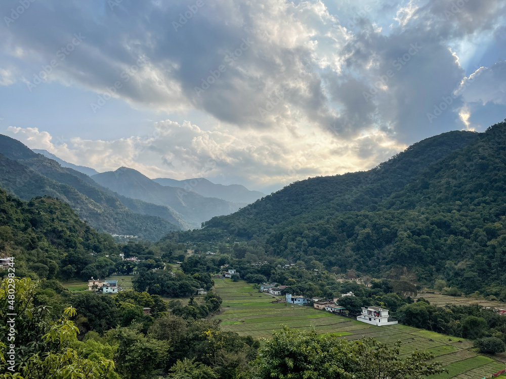 View of mountain landscape with fields in the valley and trees all around on the hills
View of mountain landscape with fields in the valley and trees all around on the hills