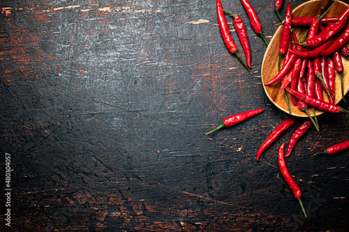 Print op canvas Wooden plate with hot chili peppers