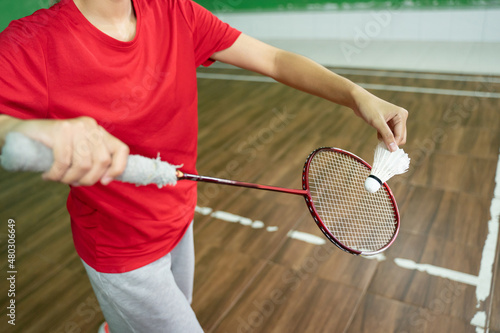 Female badminton player's holding racket and shuttlecock in service position © Odua Images